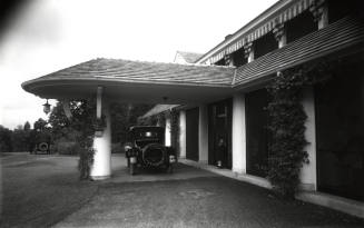 Two automobiles in front drive and under porte cochere. 