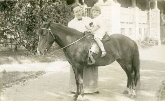 Nancy Reynolds on horse in front of Fifth Street house