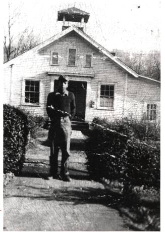 Thomas Warren standing in front of Five Row school, circa 1930