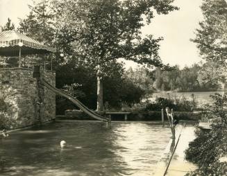 Mary and Nancy Reynolds swimming in outdoor pool with Smith Reynolds standing to the side, 1923