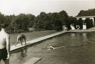 Charlie Babcock swimming in an outdoor pool in Connecticut with the dog "Brogan" nearby in 1935 ...