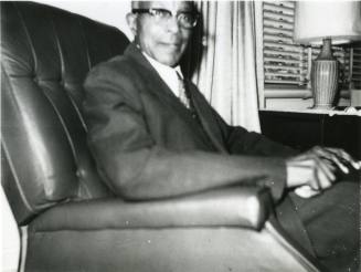Luther S. Stimson sitting in armchair, 1975